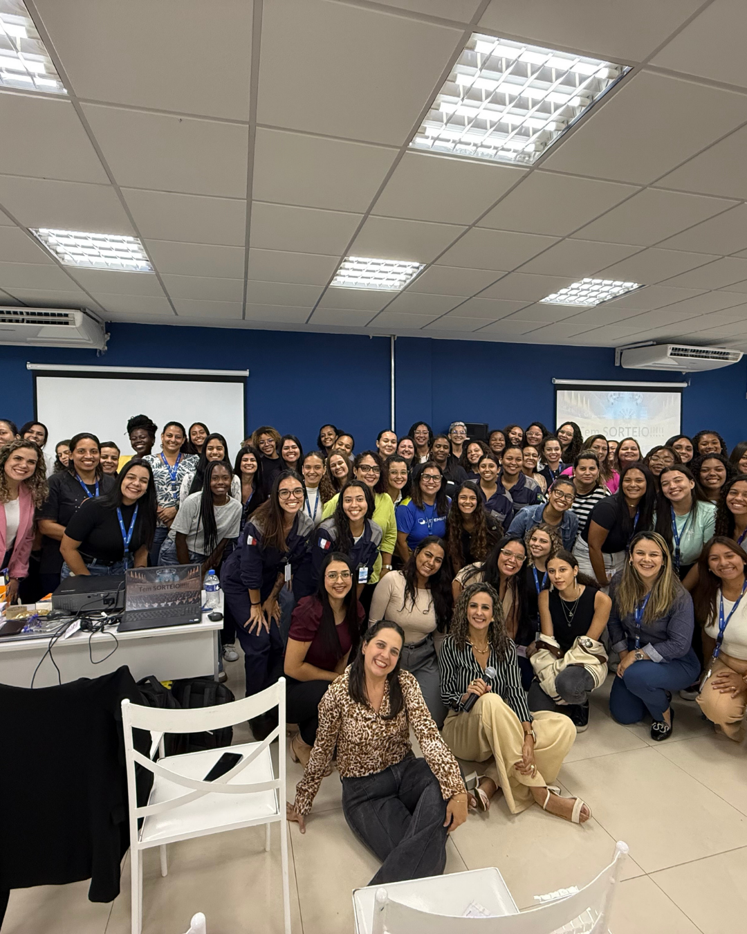Turma numerosa reunida em auditório com Camila Couto